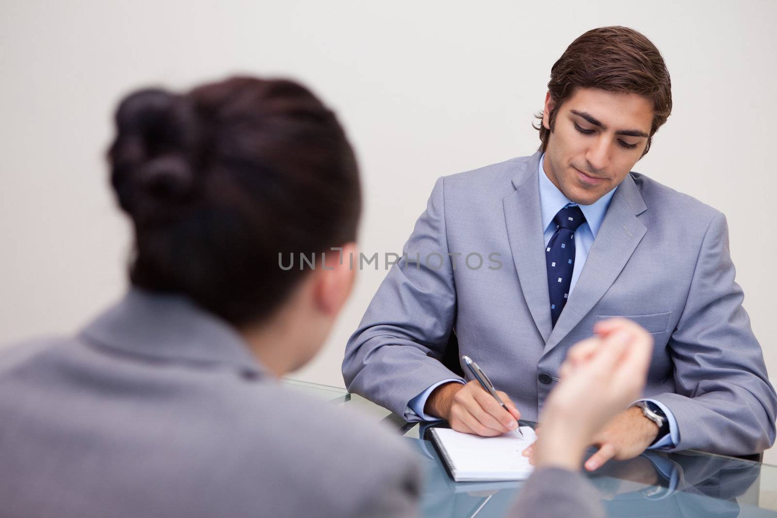 Young businessman in negotiation taking notes