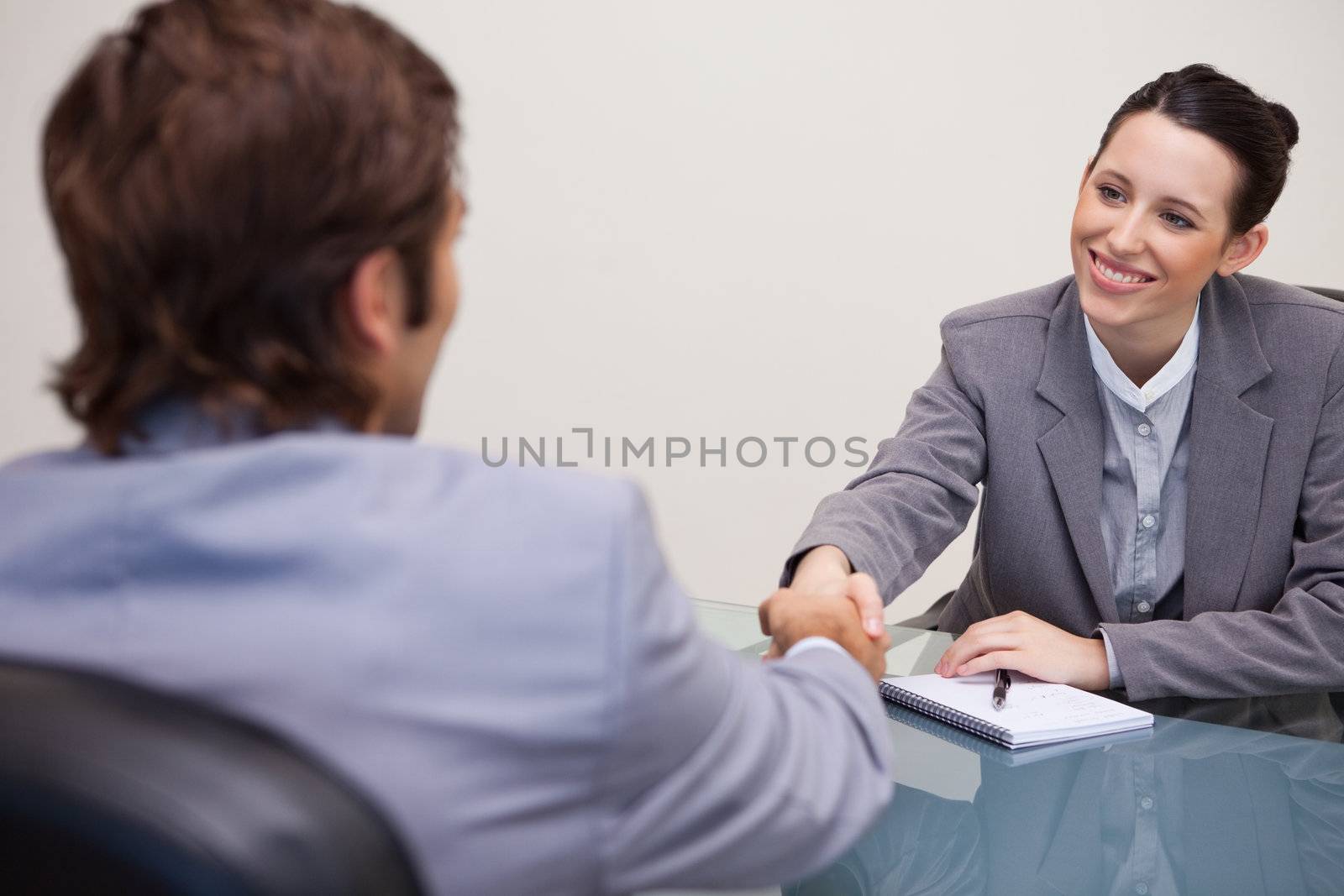 Young businesswoman welcomes customer in her office
