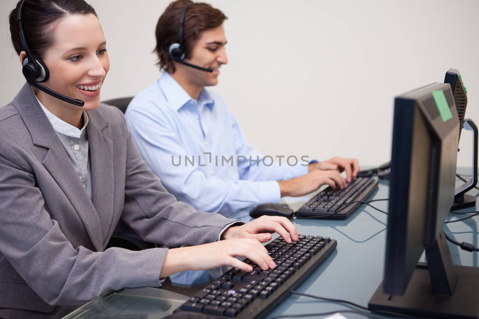 Side view of young call center agents working next to each other