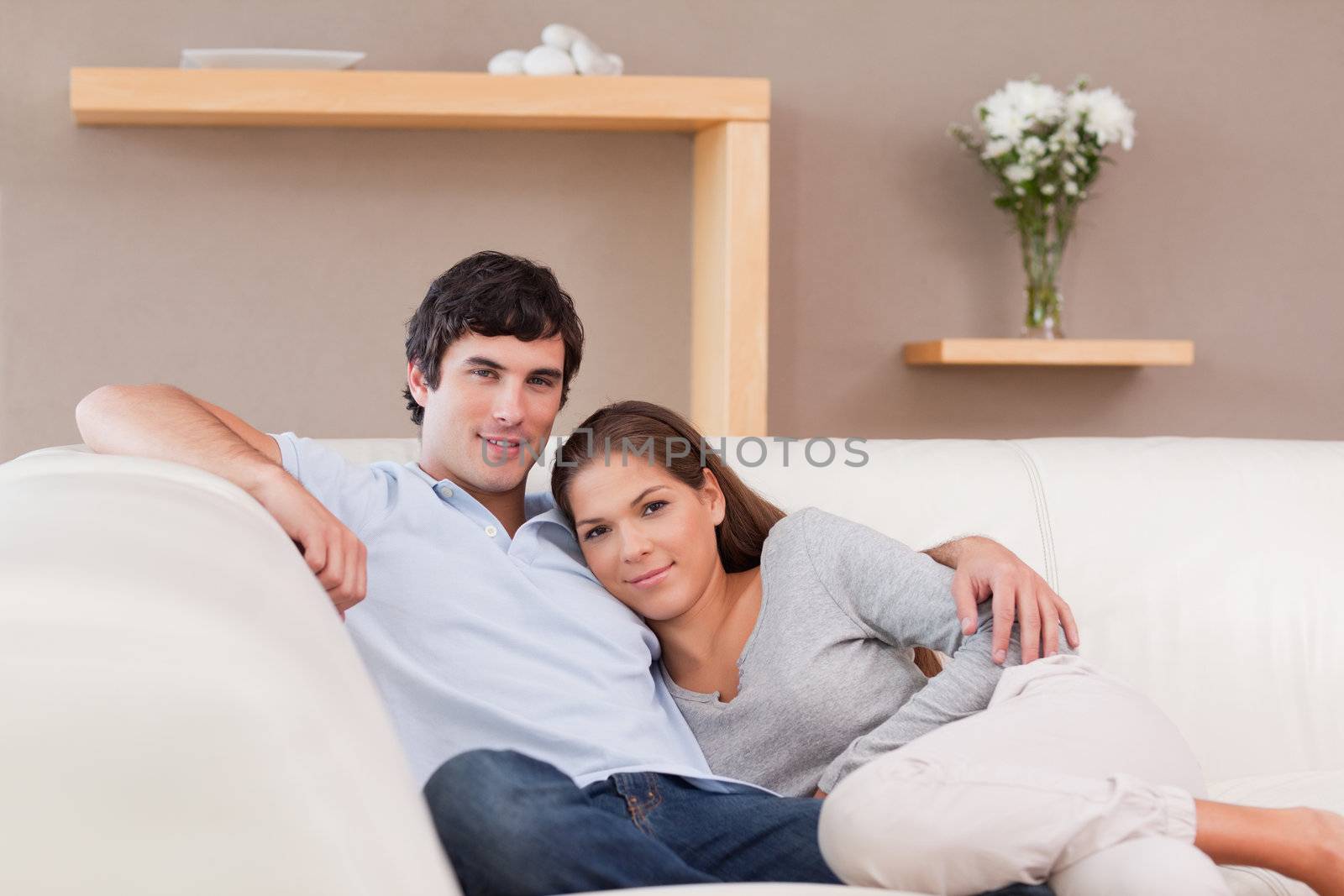 Young woman leaning on her boyfriend on the sofa
