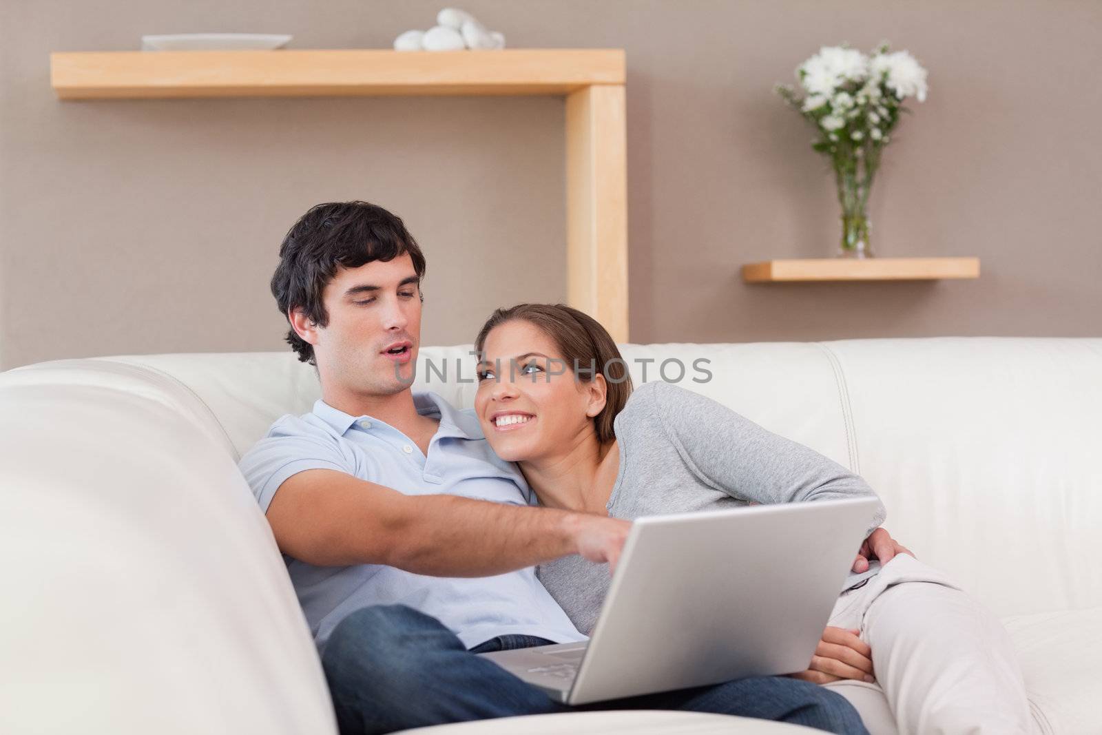 Young couple with their laptop on the sofa