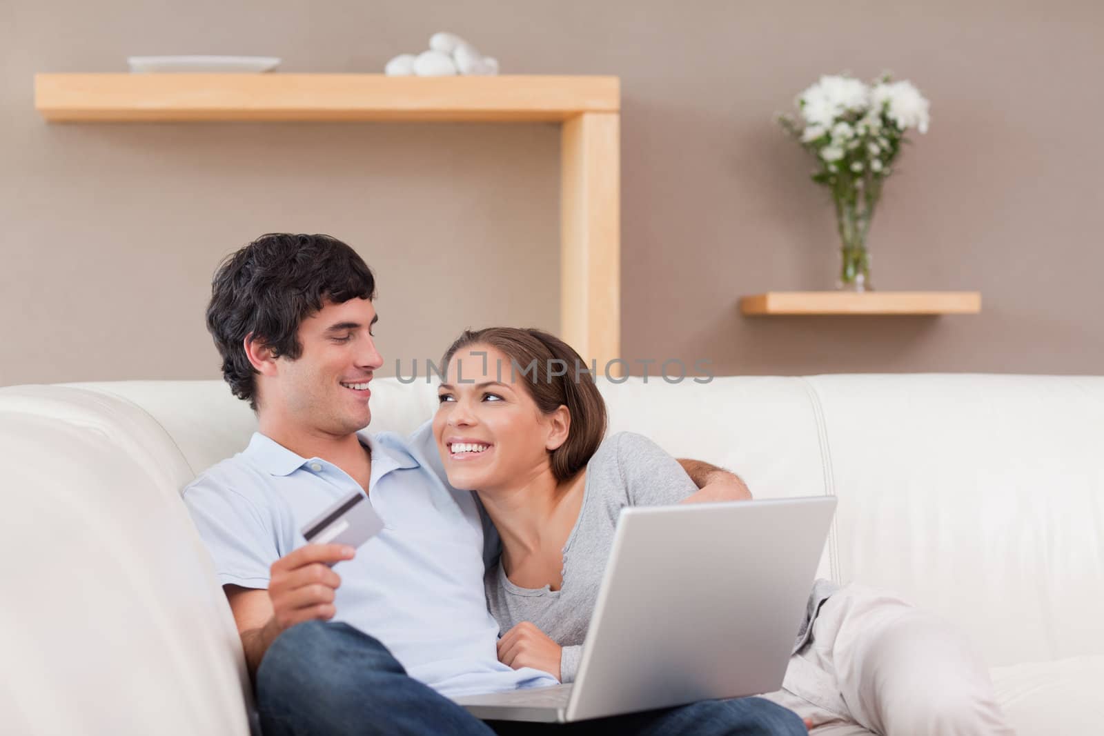 Cheerful young couple booking holiday online