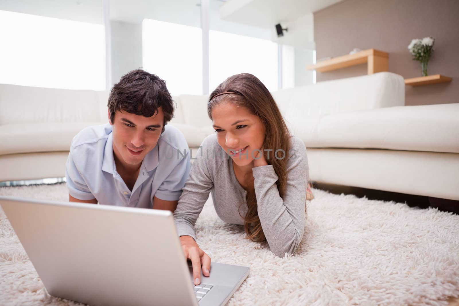Young couple with laptop on the floor