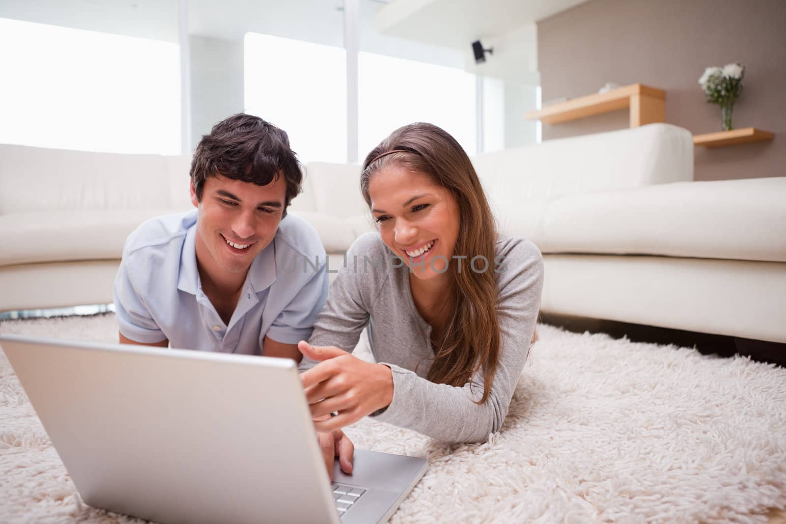 Young couple with notebook on the floor