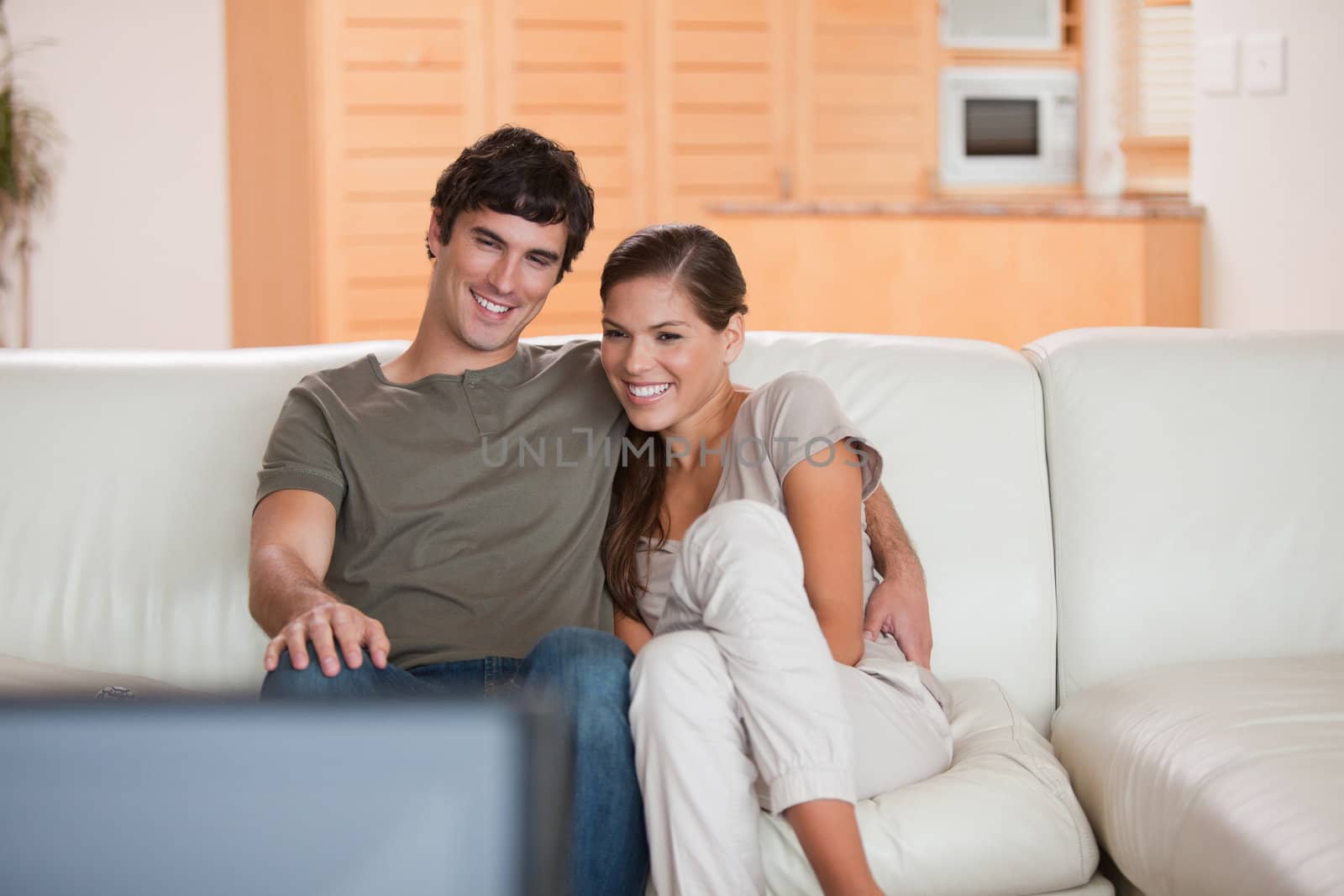 Young couple on the sofa watching a movie together