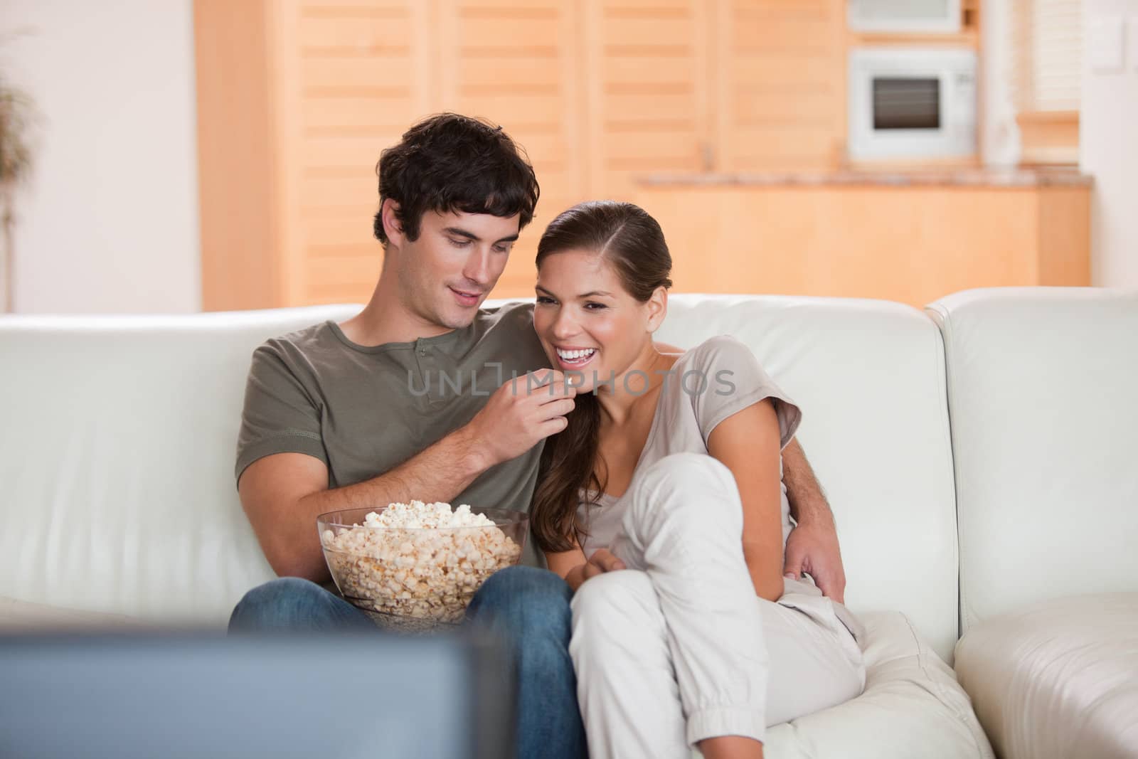 Young couple on the couch watching a movie together