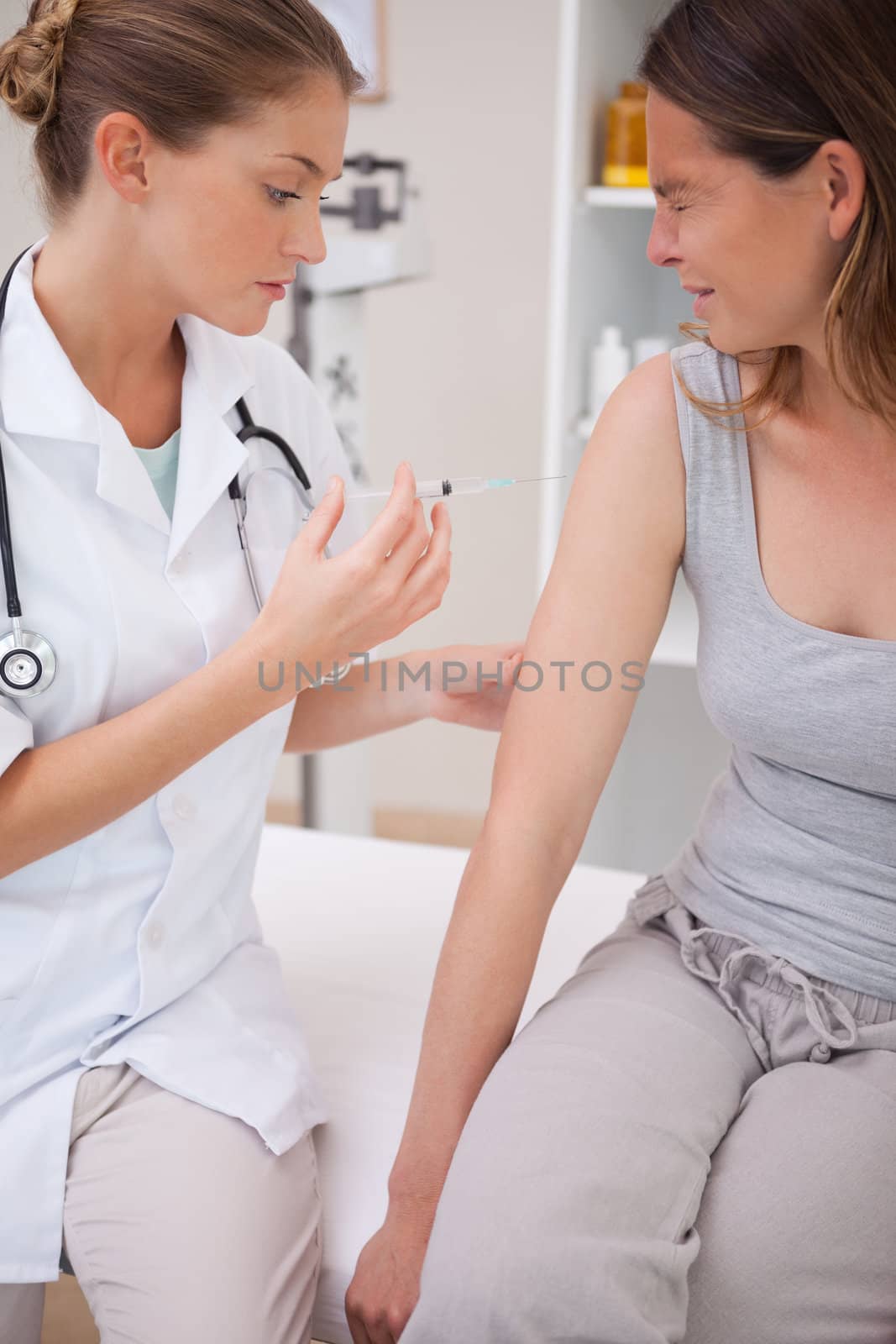 Patient receiving painful injection from doctor