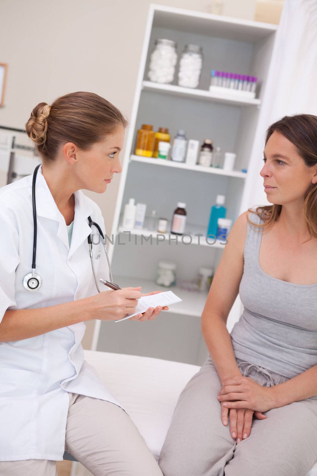 Doctor with notepad talking with patient