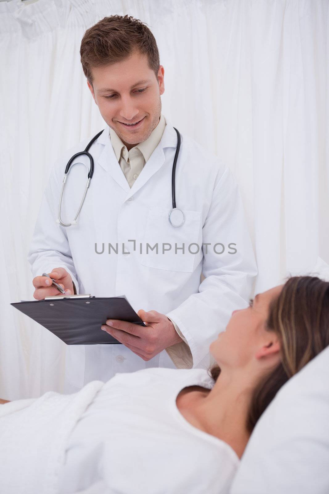 Doctor standing next to his bedridden patient