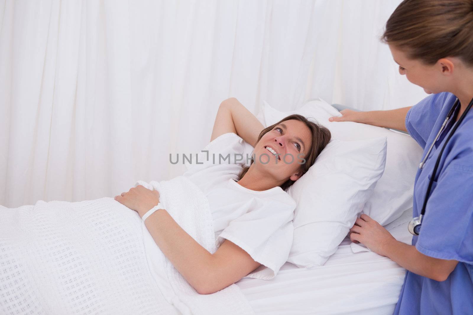 Surgeon plumping up pillow for patient