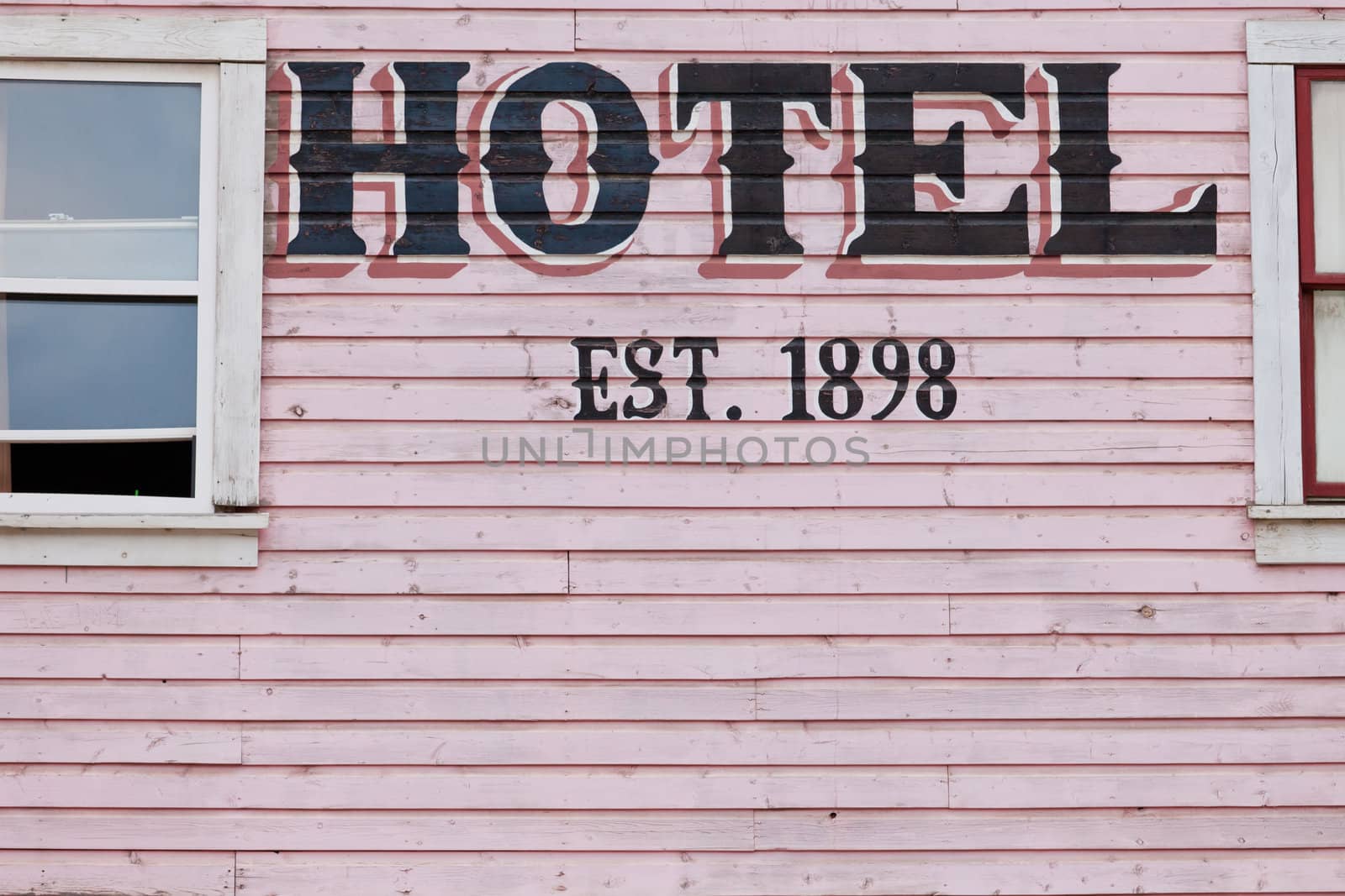 Detail of painted pink historic hotel wooden facade siding