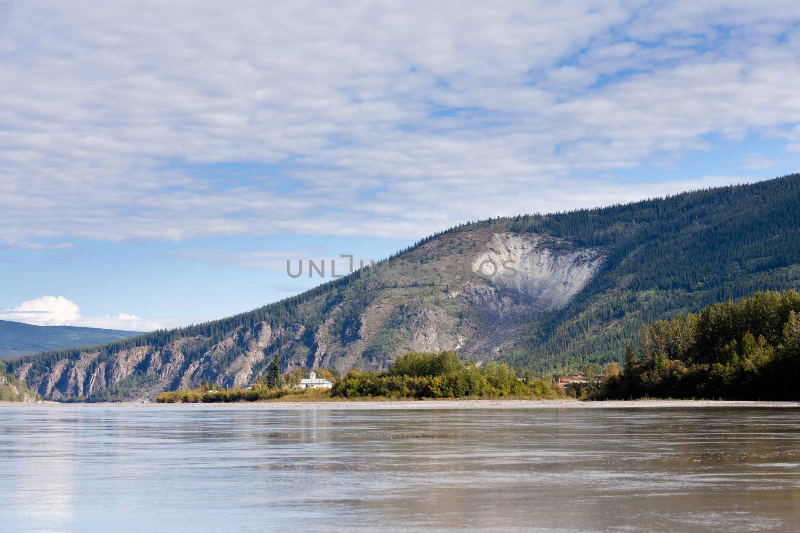 View of goldrush town of Dawson City and Moosehide Slide on hillside behind seen from Yukon River, Yukon Territory, Canada