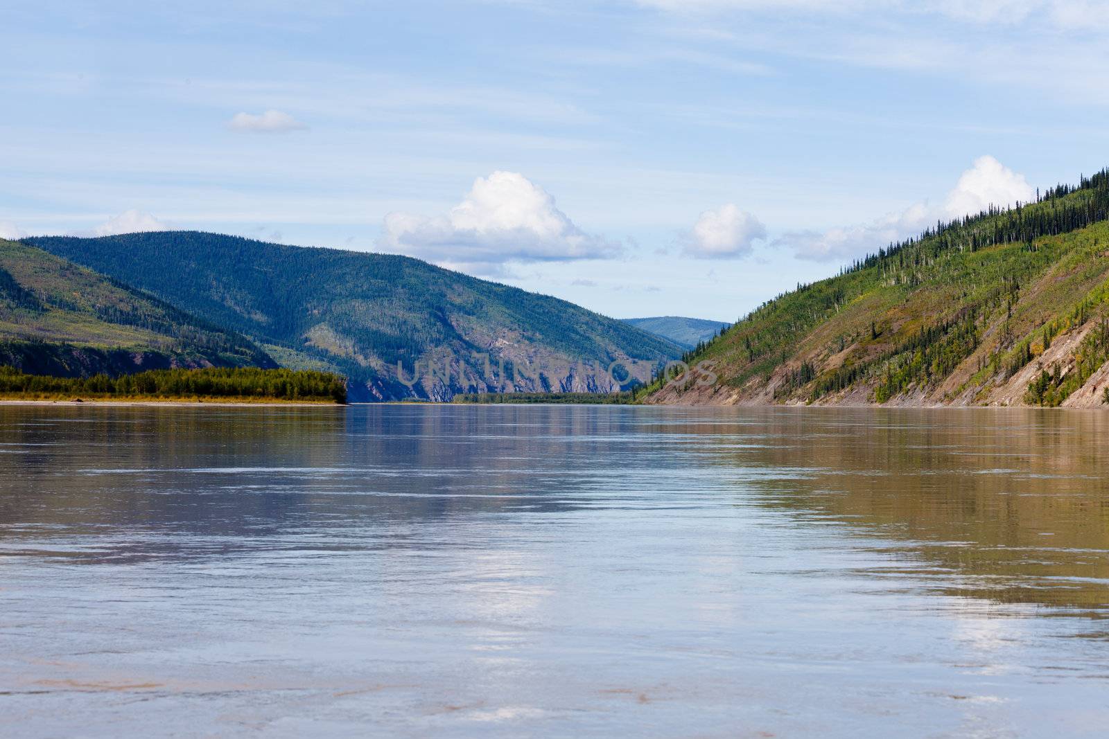 Boreal forest hills at river bank of Yukon River, Yukon Territory, Canada, near Dawson City forming a beautiful northern riverscape.