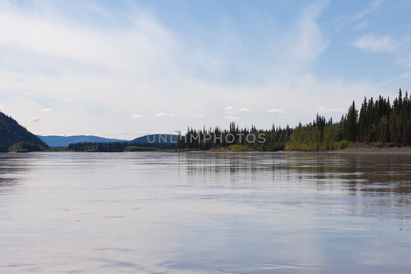 Boreal forest hills at river bank of Yukon River, Yukon Territory, Canada, near Dawson City forming a beautiful northern riverscape.