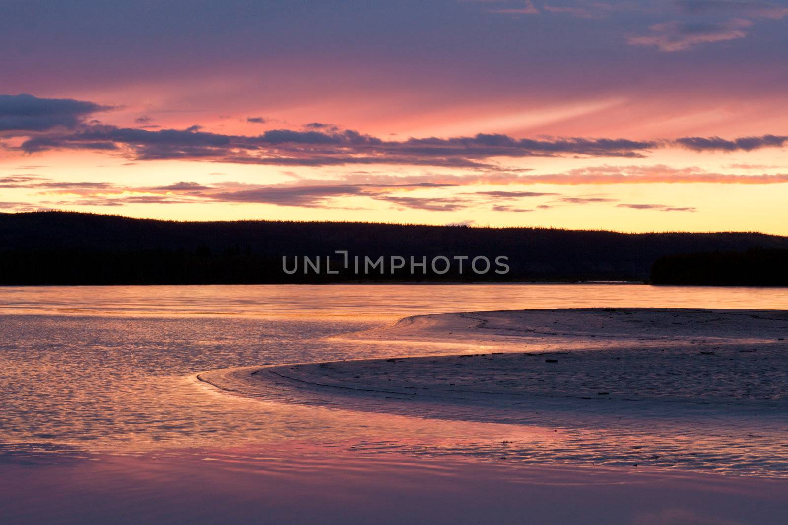 Beautiful sunset over wilderness of Yukon River, Yukon Territory, Canada, near Dawson City forming a northern riverscape.