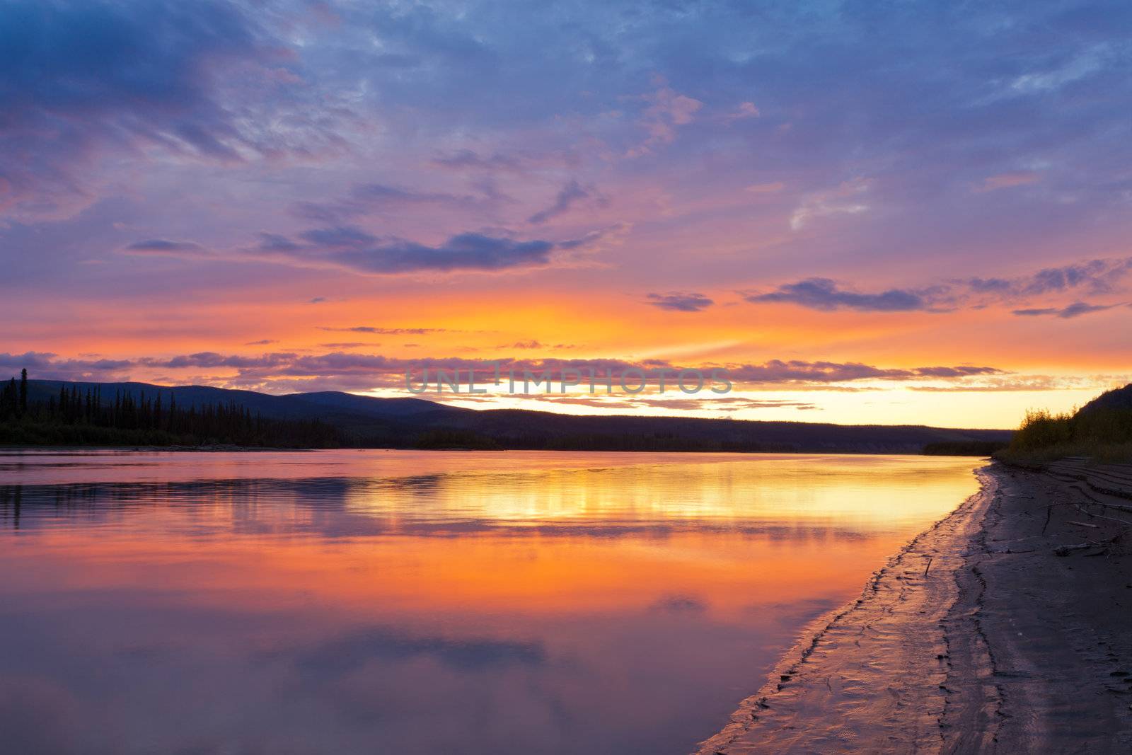 Beautiful sunset over wilderness of Yukon River, Yukon Territory, Canada, near Dawson City forming a northern riverscape.