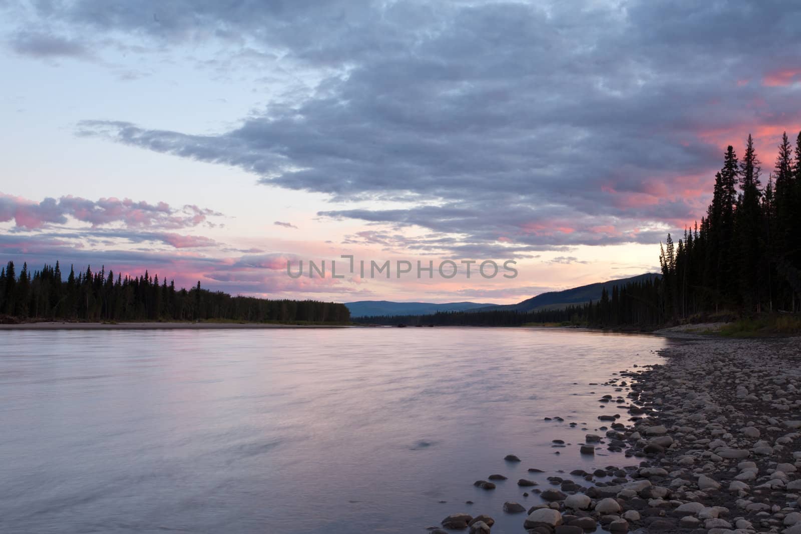 Beautiful sunset over wilderness of Steward River, central Yukon Territory, Canada, near town of Mayo forming a northern riverscape.