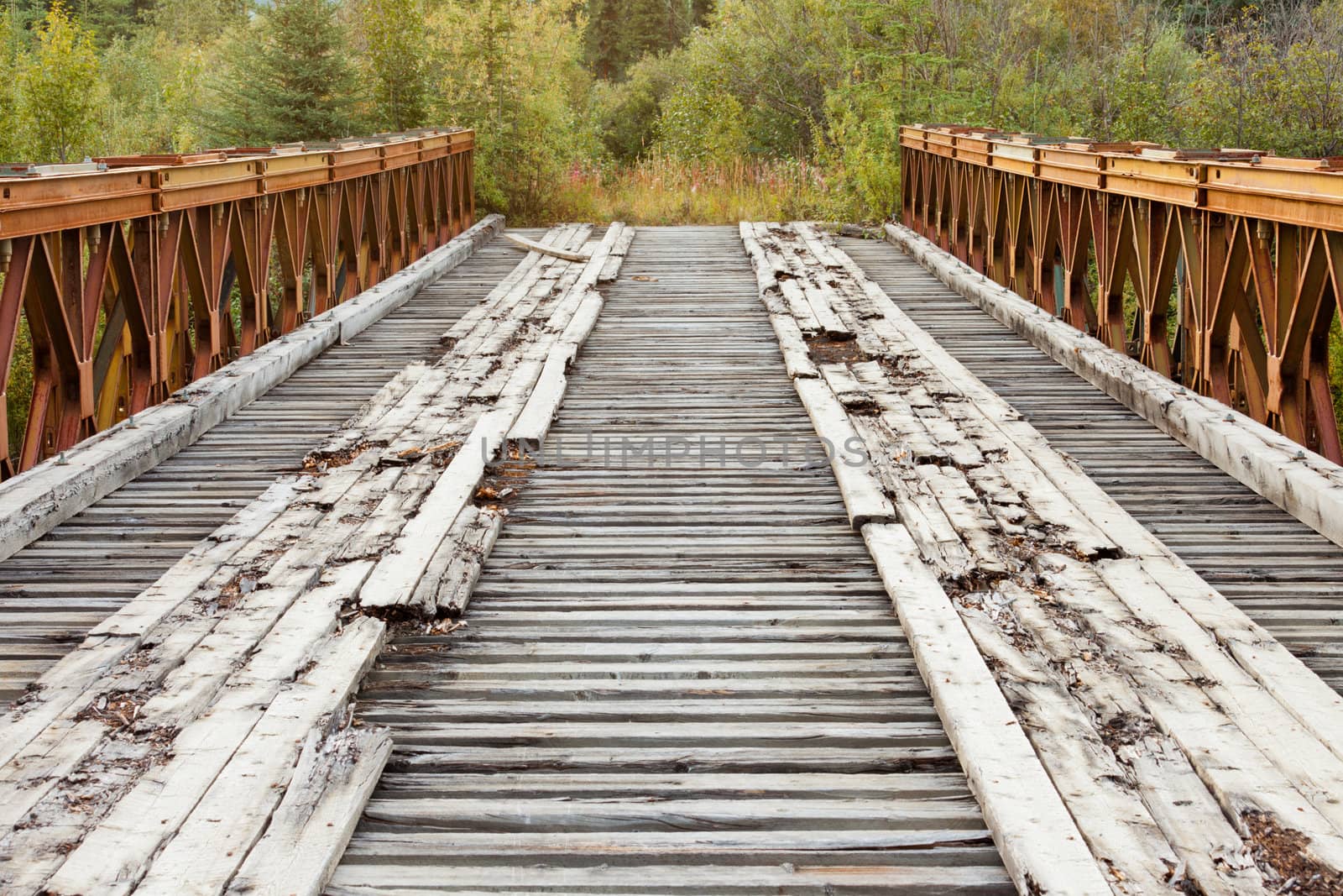 Old rotten abandoned steel and wood bridge leading to nowhere