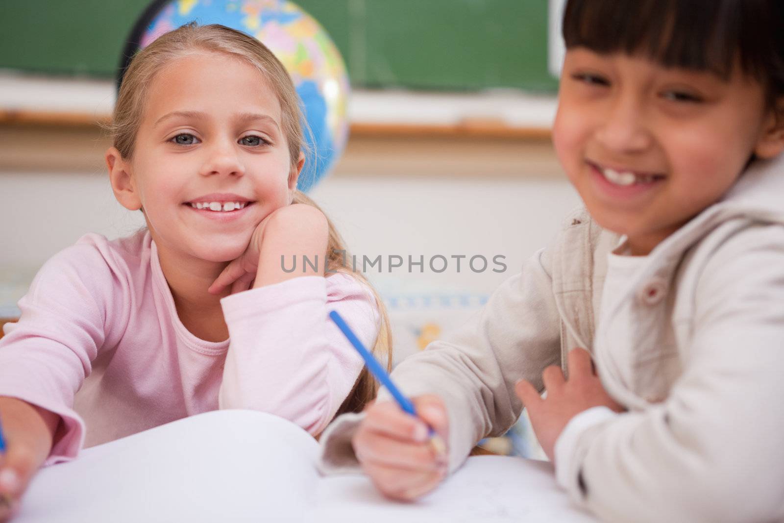 Schoolgirls doing classwork while looking at the camera