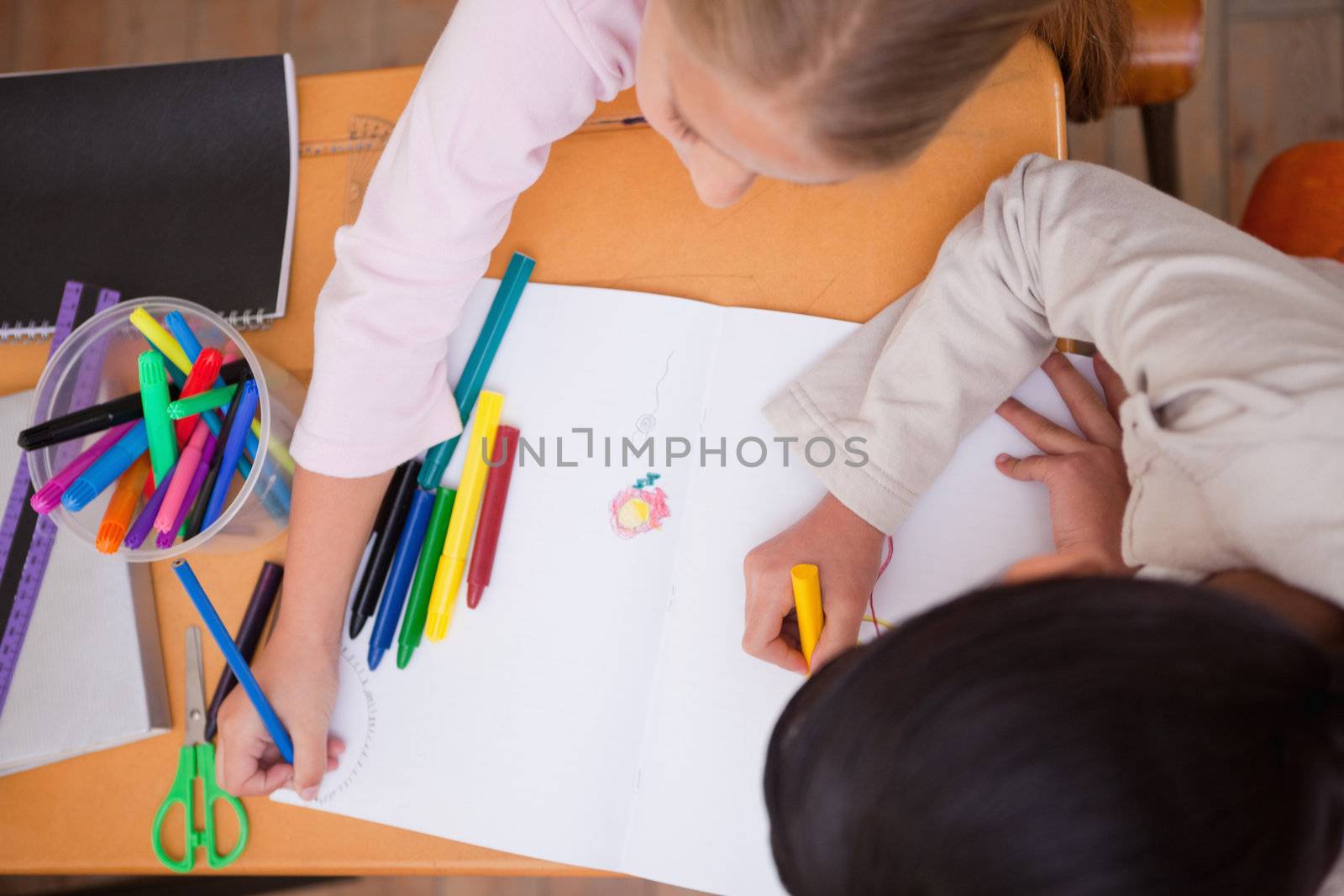Above view of schoolgirls drawing in a classroom