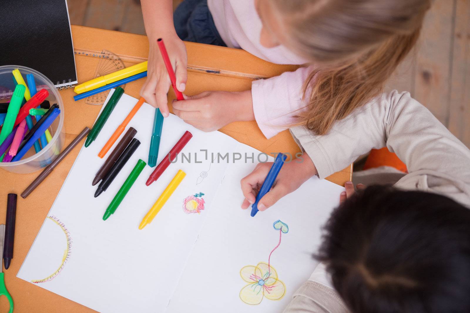 Above view of little schoolgirls drawing in a classroom