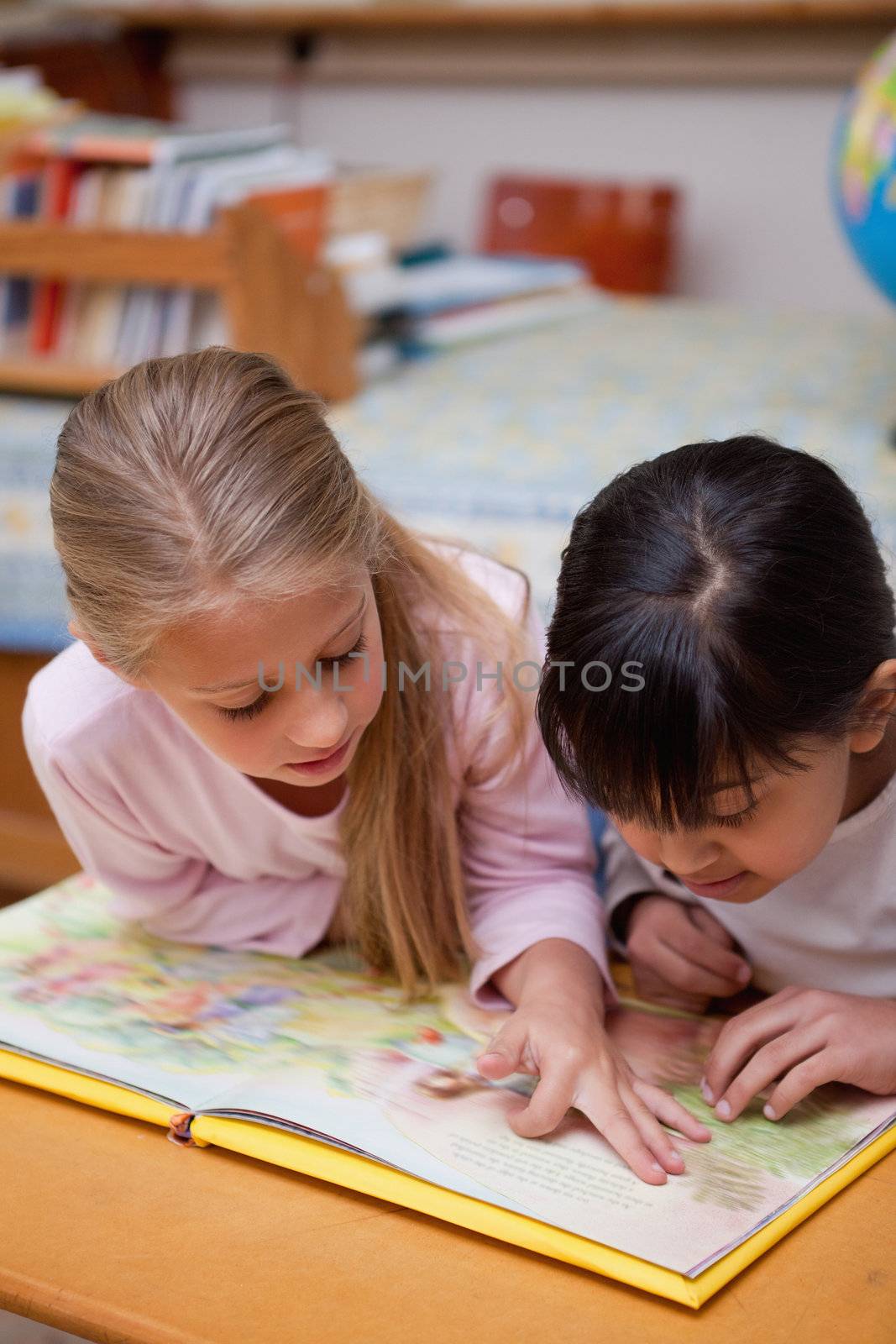 Portrait of schoolgirls reading a fairy tale in a classroom