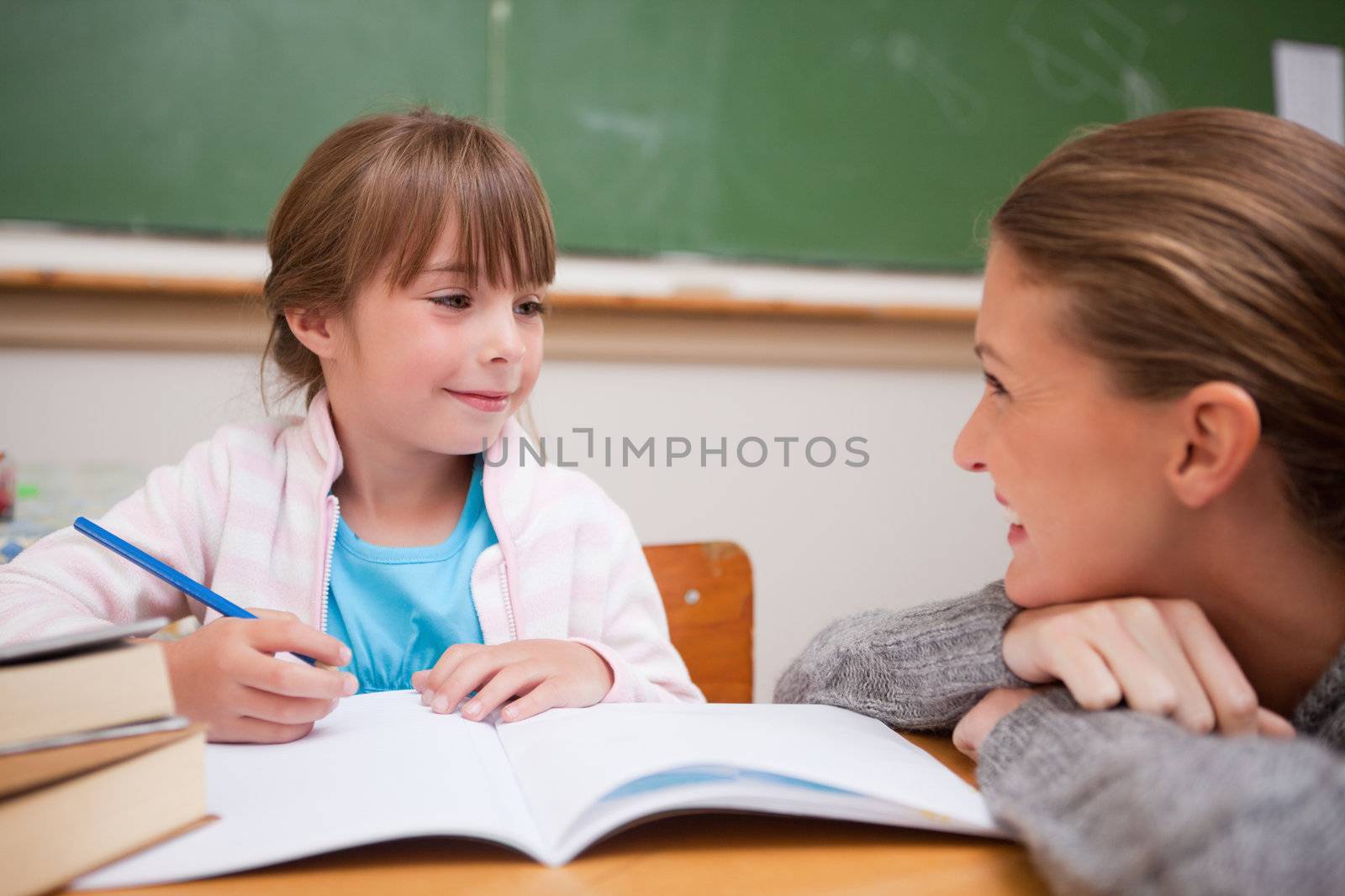 A teacher and a schoolgirl talking in a classroom