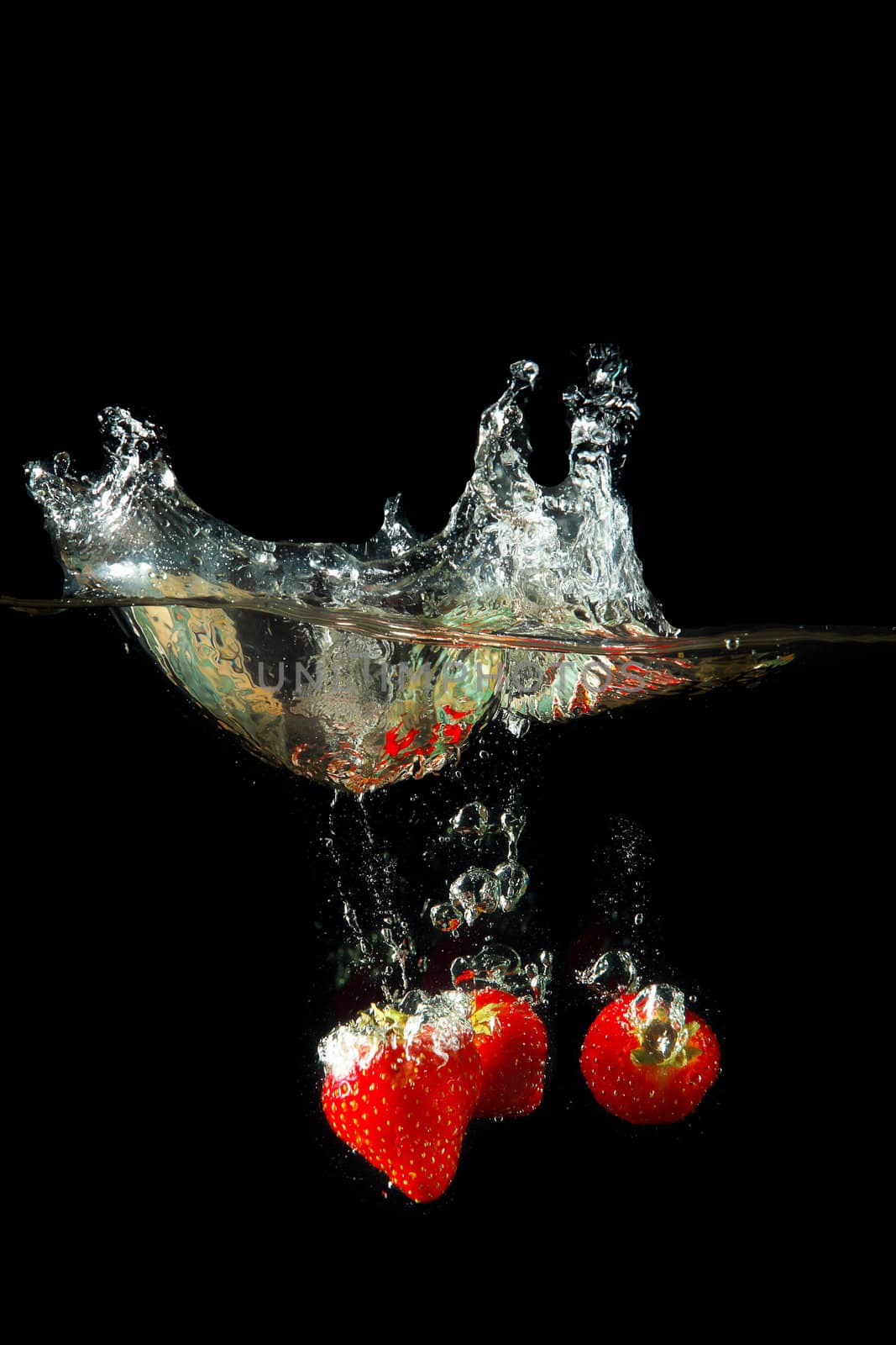 Colored red paprika in water splashes on black background