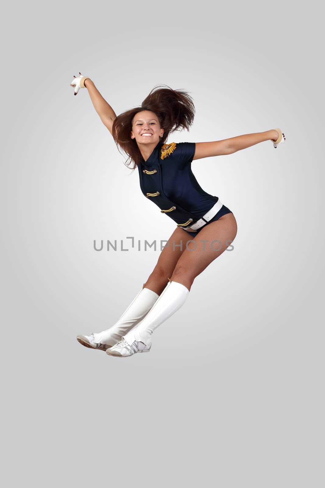 Young female dancer jumping against white background