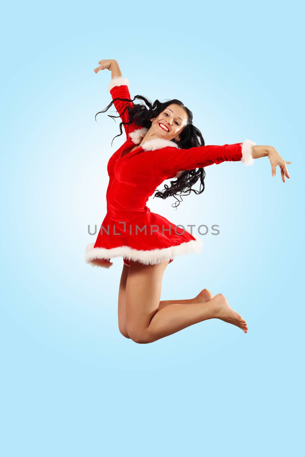 Happy smiling woman in red xmas costume jumping high