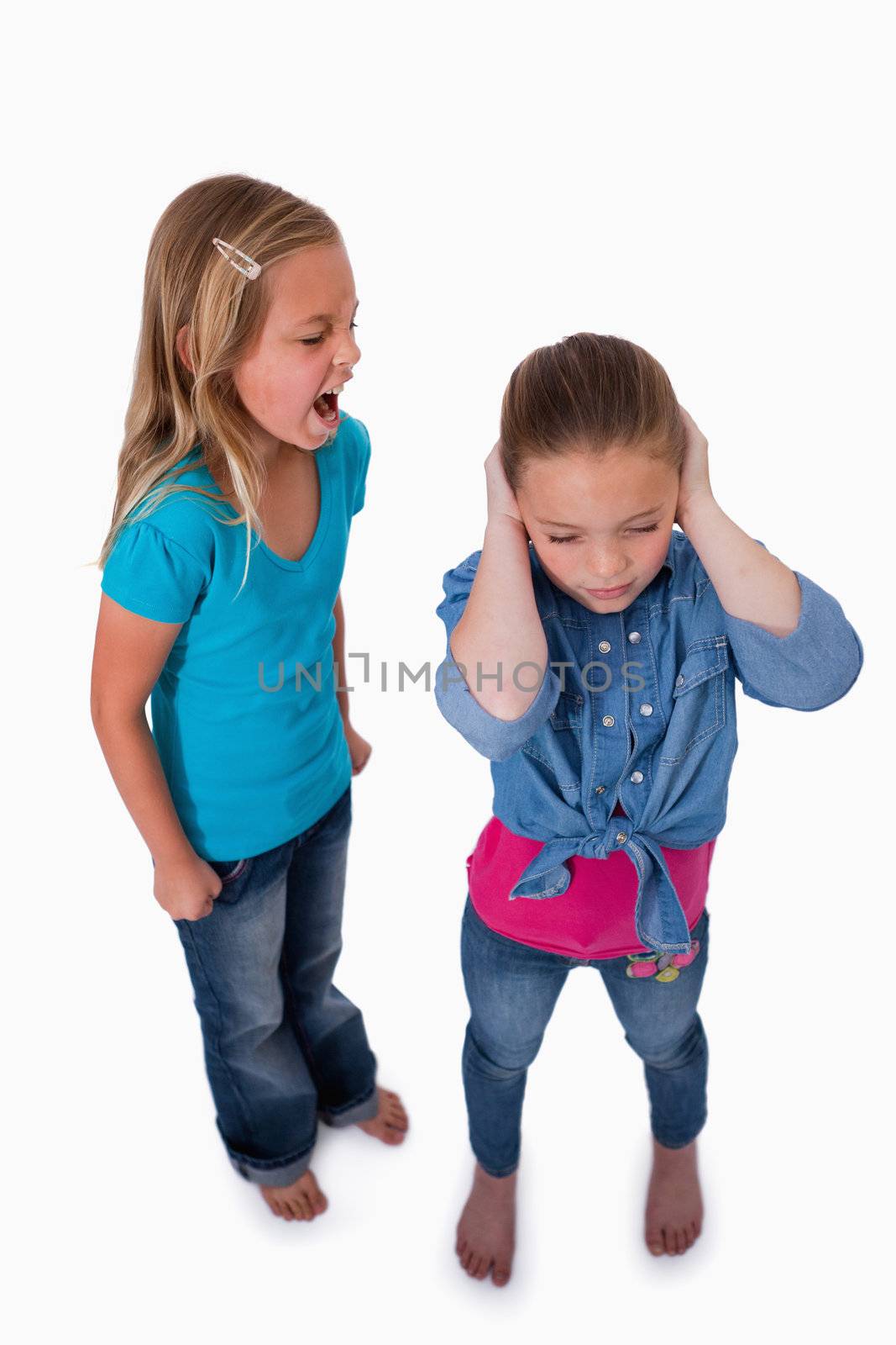 Portrait of an unhappy girl screaming at her friend against a white background