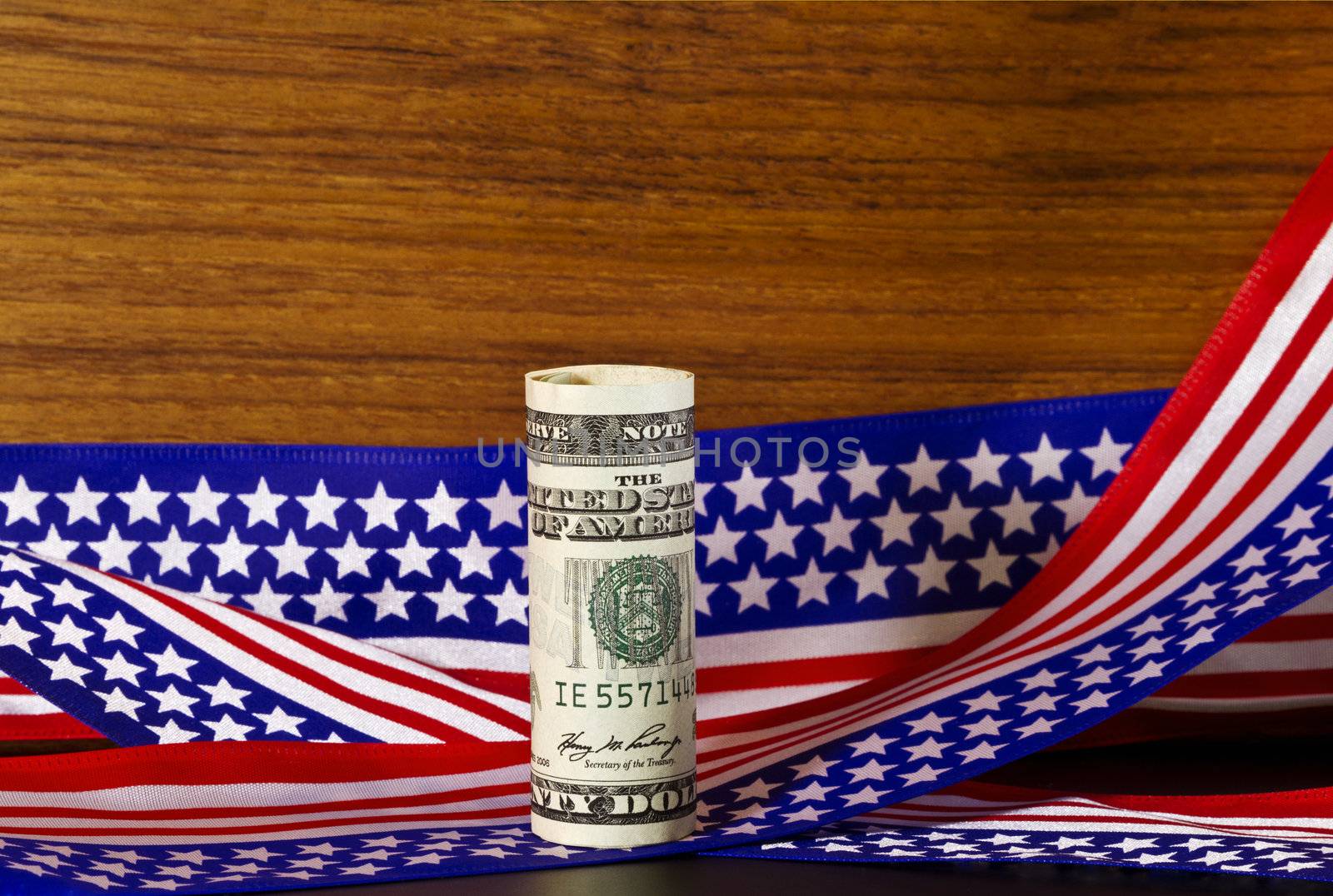 American currency placed in front of stars and stripes ribbon that picks up on USA flag motif.  Currency  suggests federal funding, on issues that impact the nation's economy or future.  Image suggests national investment or support of federal economic strategies. 