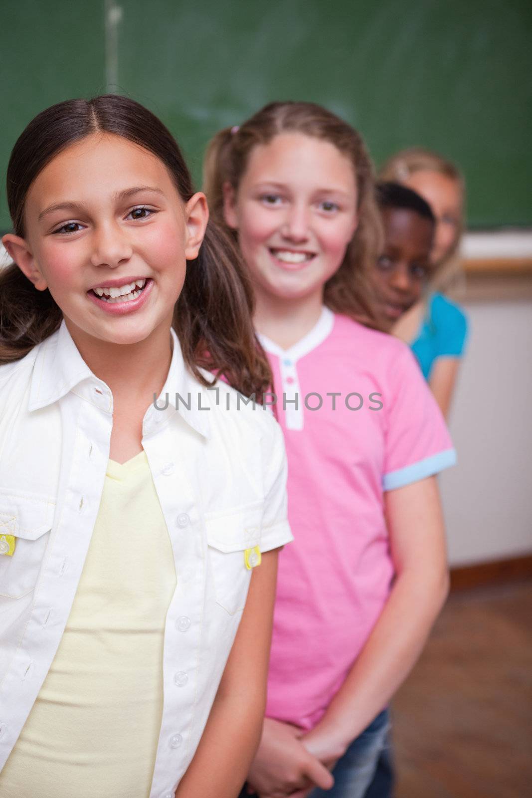 Portrait of classmates posing in a row in a classroom