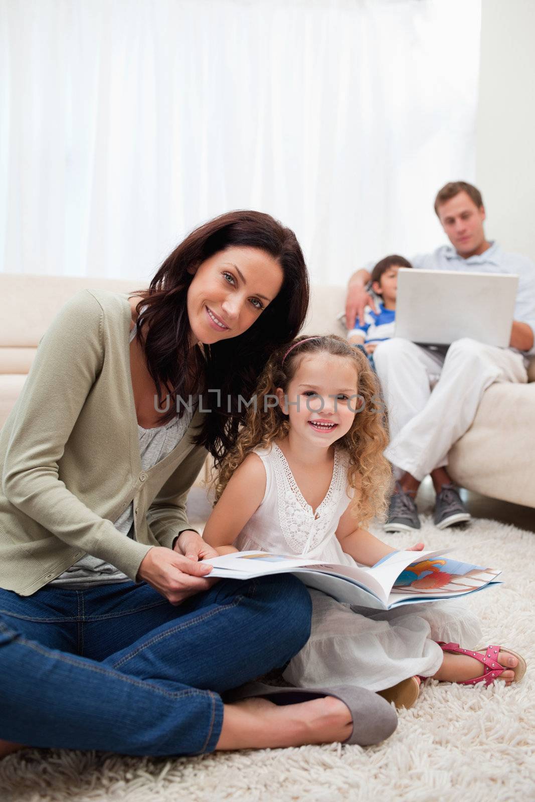 Mother and daughter reading book together by Wavebreakmedia
