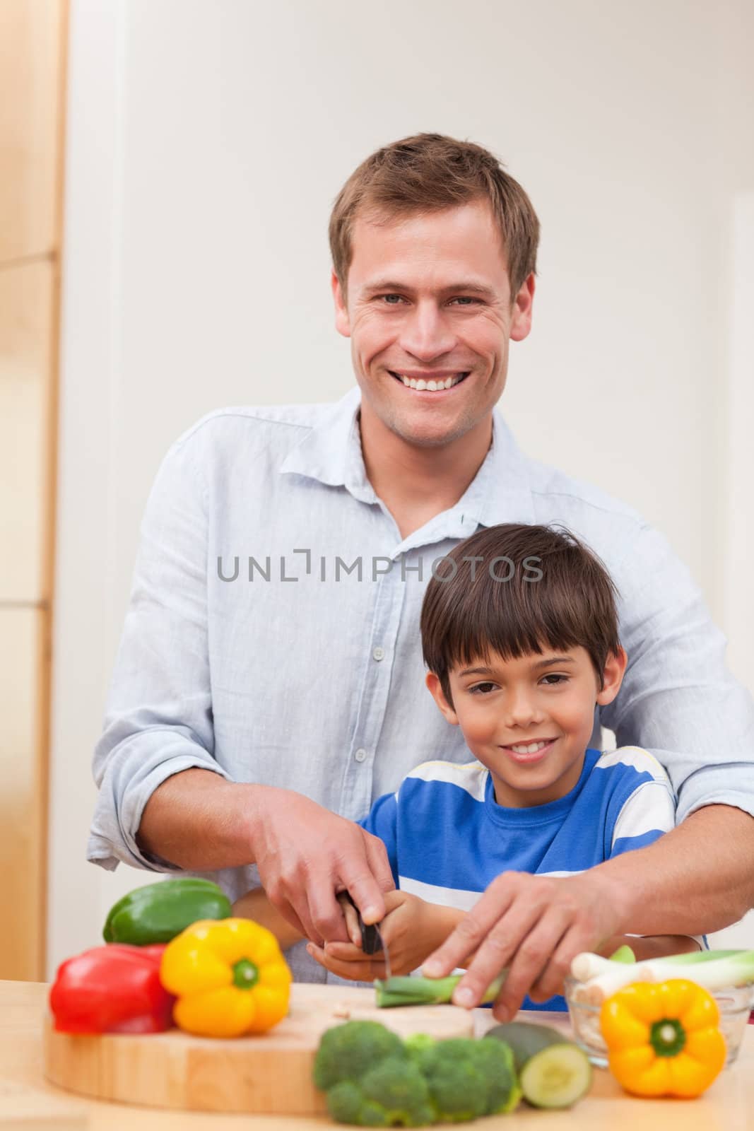 Father and son cutting vegetables together