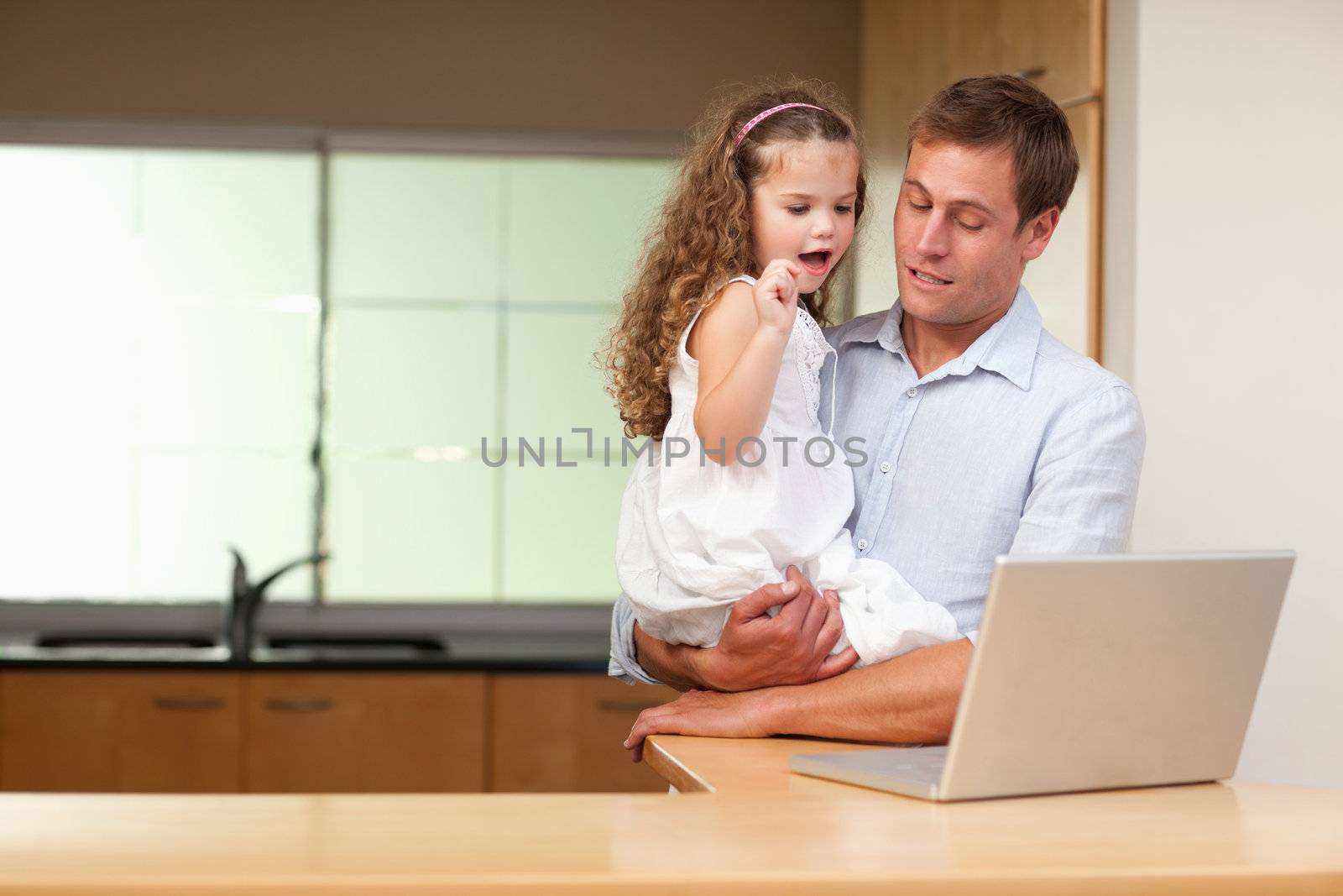 Little girl is interested in her fathers laptop