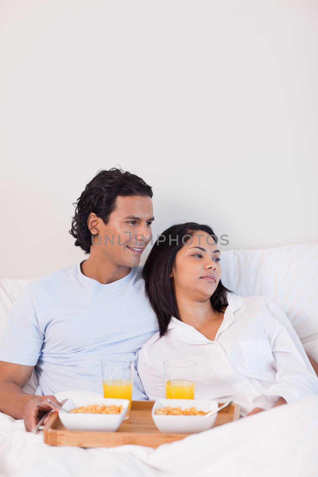 Young couple eating breakfast in the bed