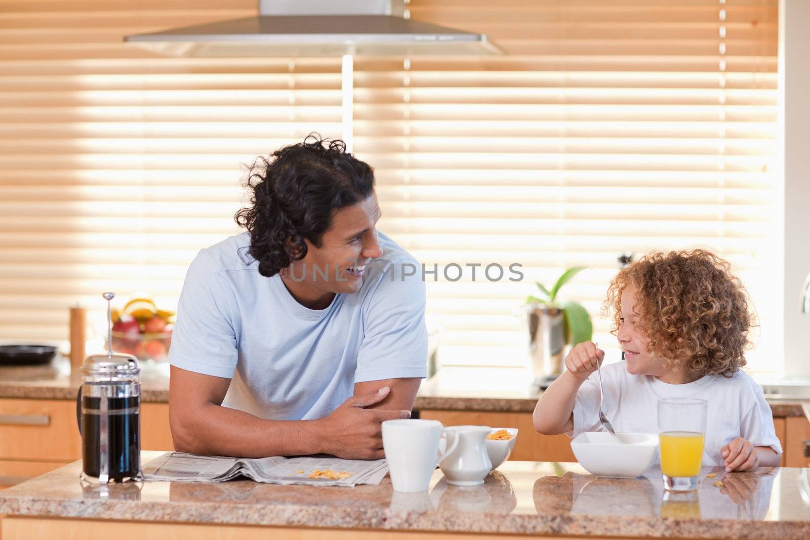 Young father and daughter having breakfast in the kitchen