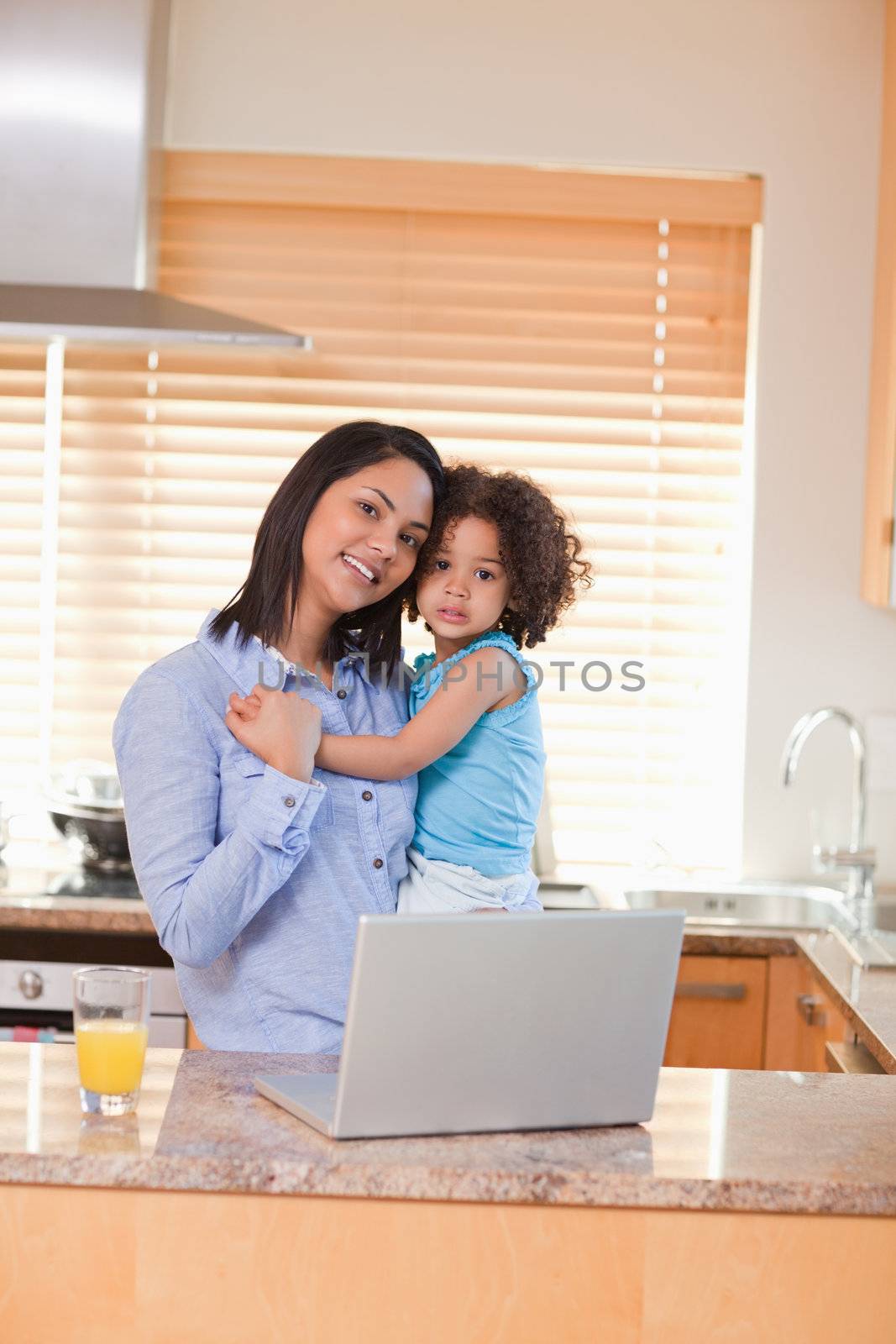 Mother and daughter with laptop in the kitchen by Wavebreakmedia