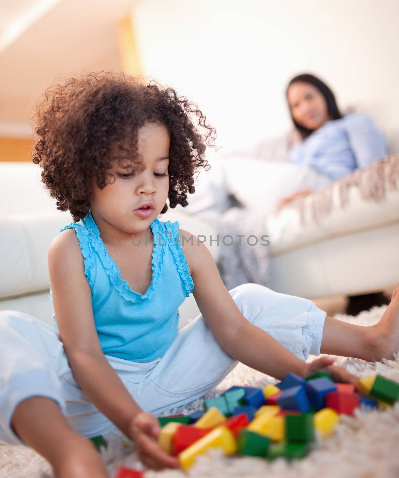 Young girl in the living room playing with toy blocks