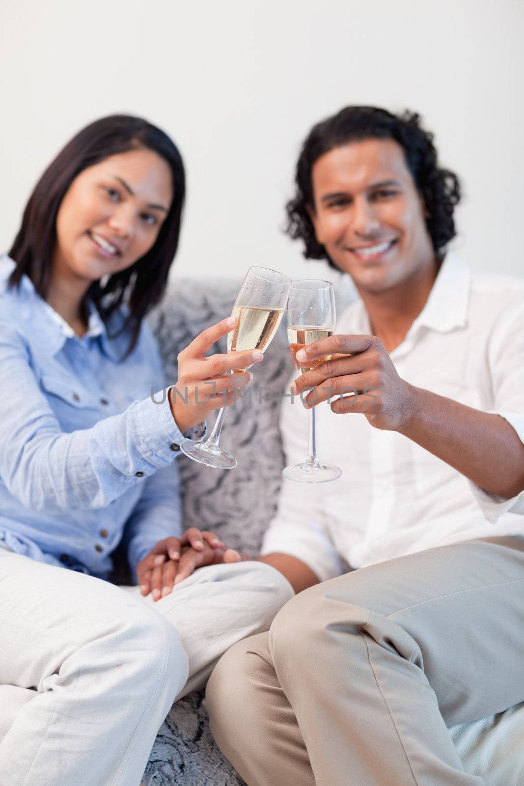 Young couple celebrating with sparkling wine in the living room