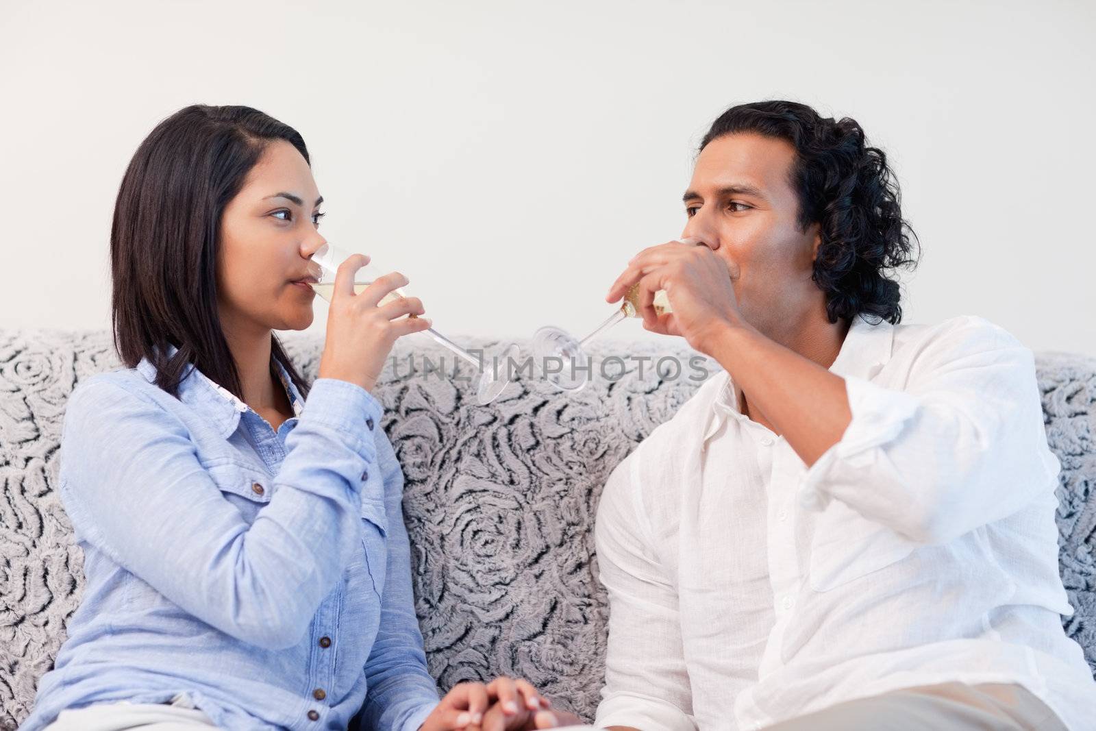 Young couple drinking sparkling wine in the living room