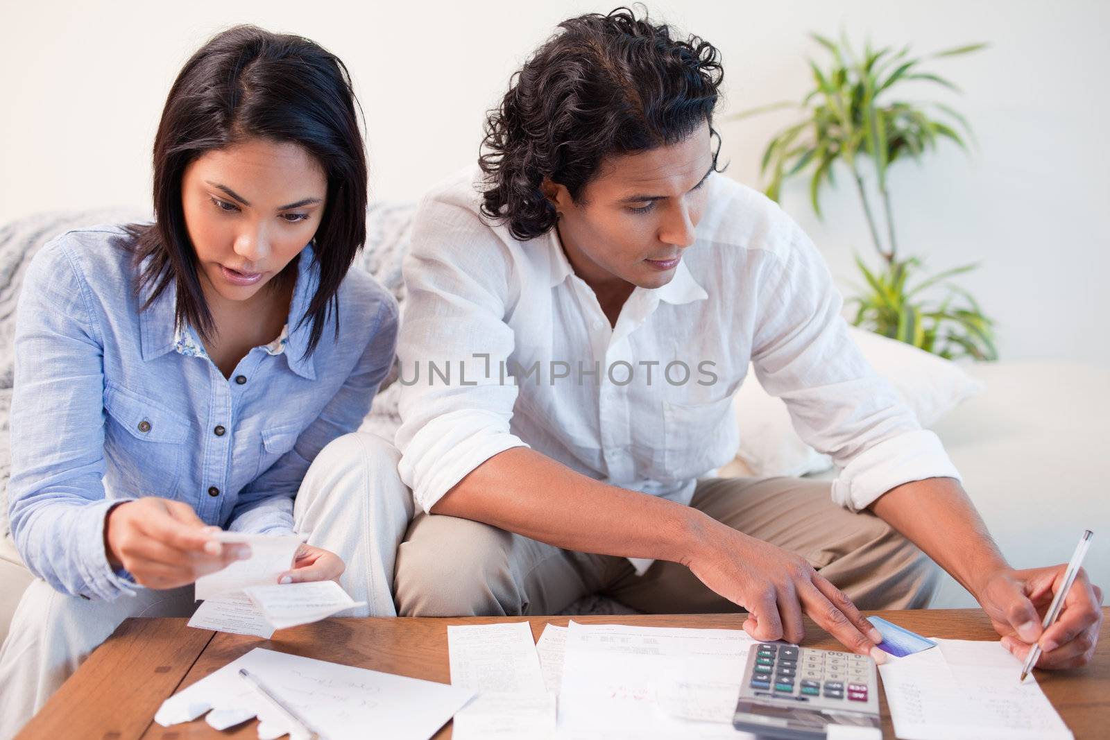 Young room checking bills in the living room