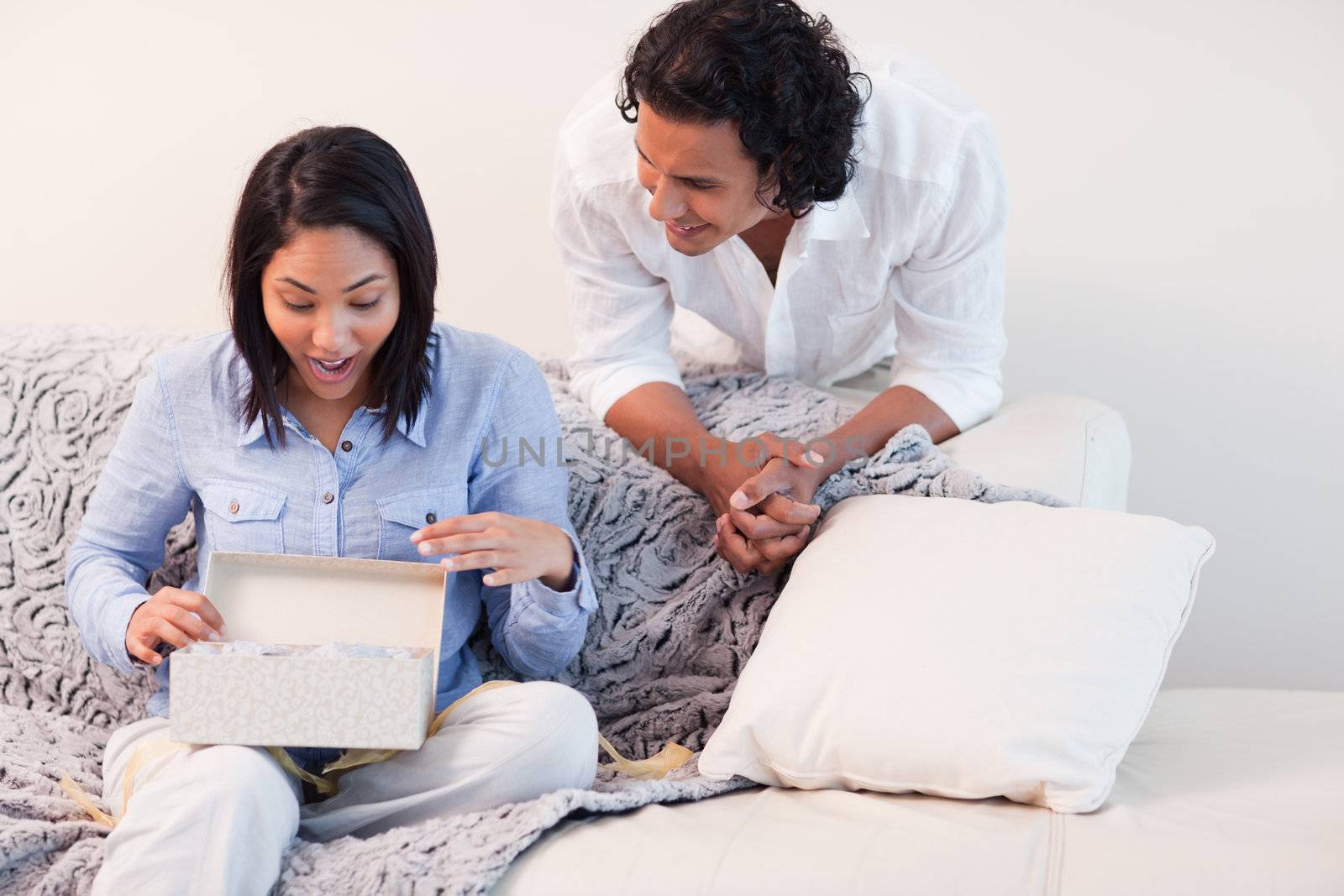 Young woman opening the present she got from her boyfriend