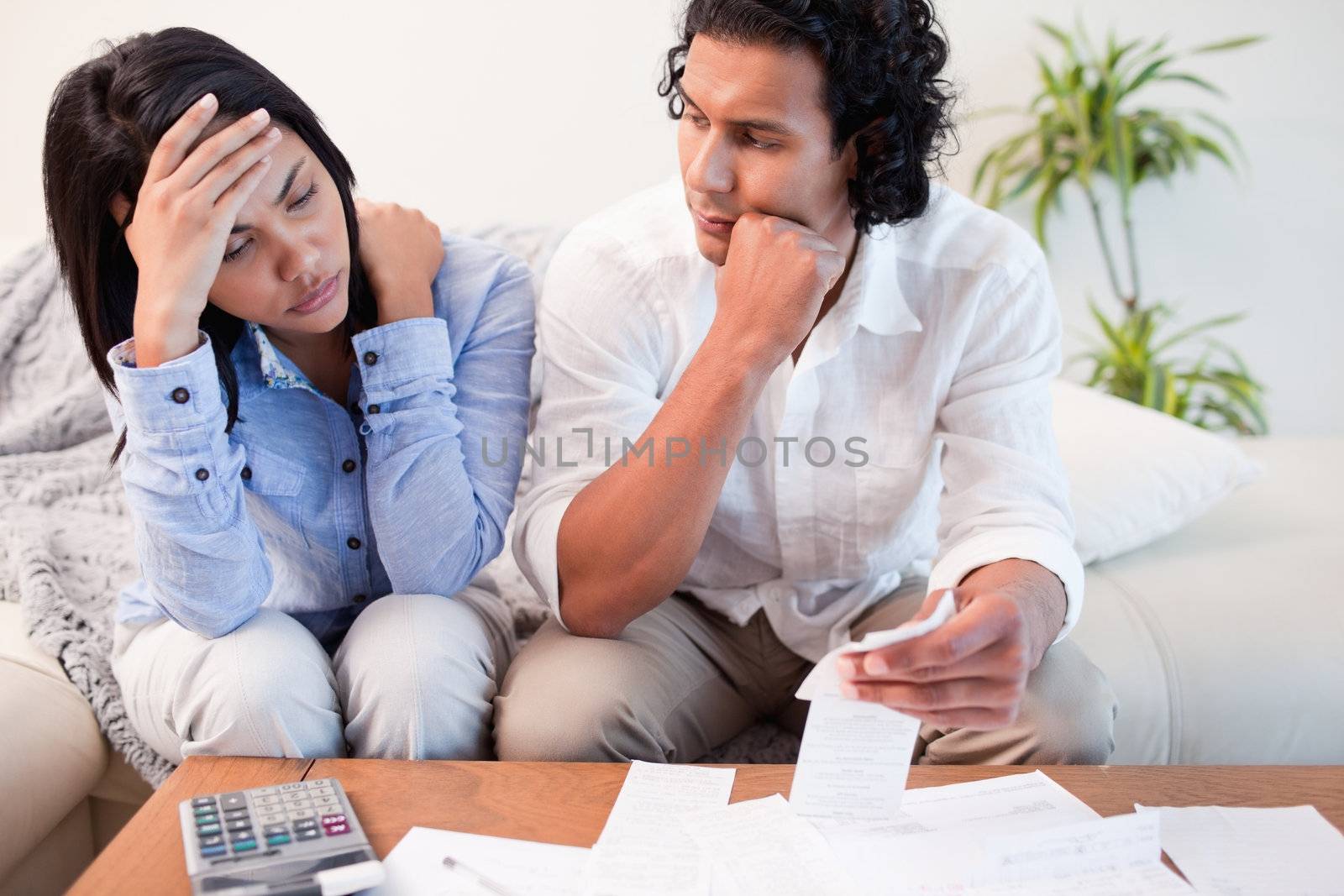 Frustrated young couple checking their bills