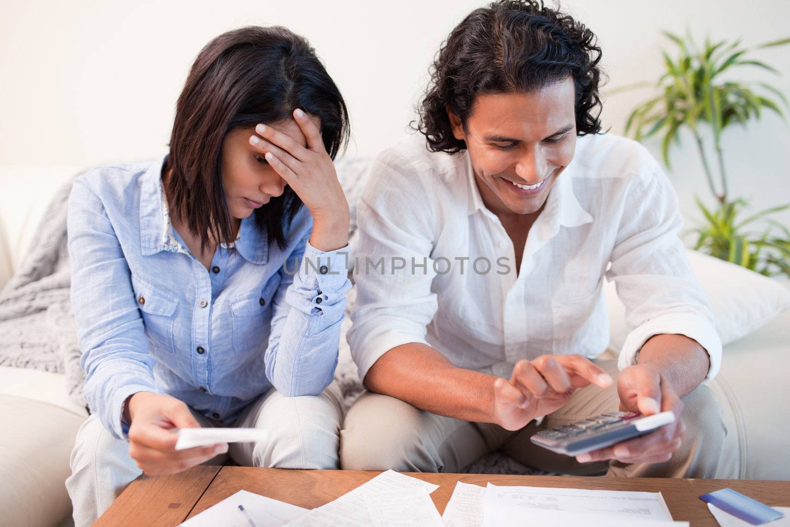 Young couple checking their bills in the living room