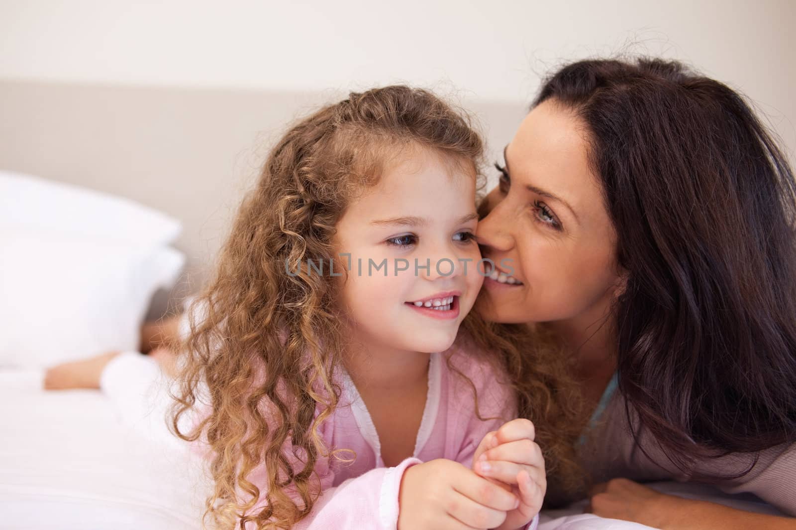 Young mother whispering into her daughters ear