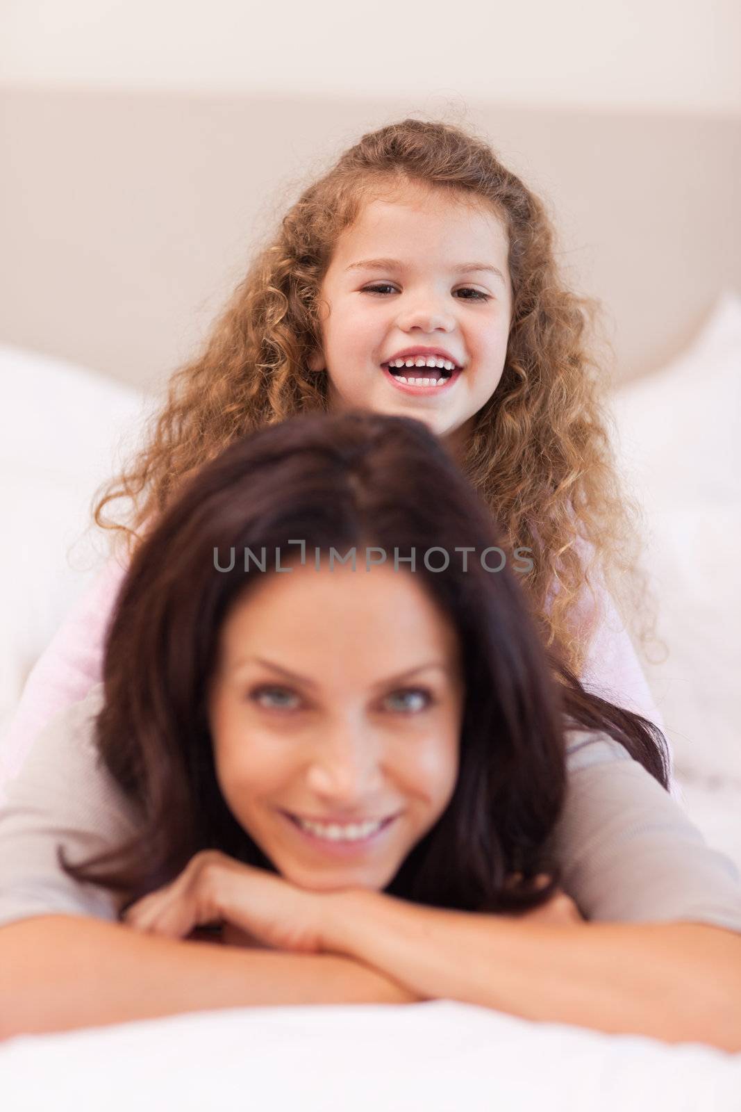 Little girl sitting on her mothers back