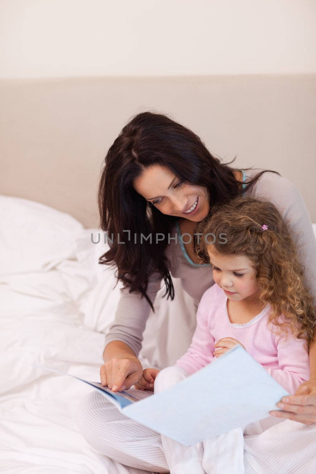 Young mother reading bedtime story for her daughter