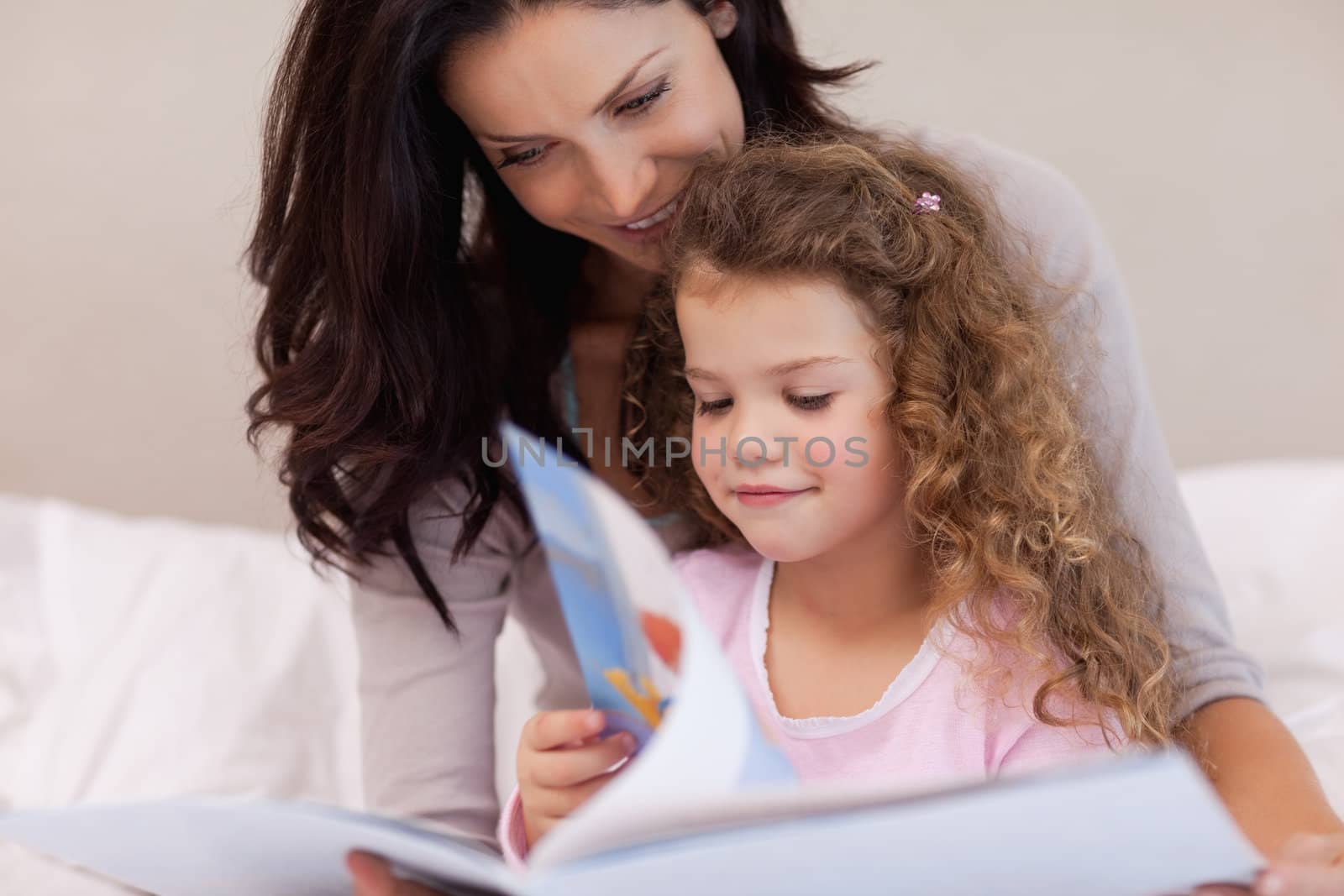 Young mother reading a book with her daughter